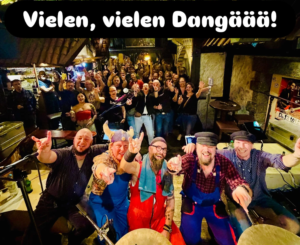 Foto von der Band auf der Bühne mit dem Publikum im Hintergrund